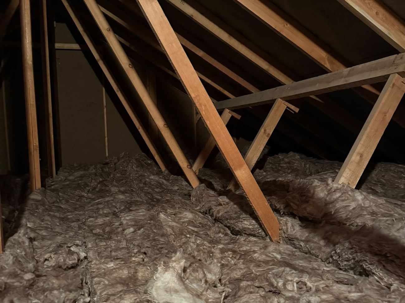 Existing wool redistributed between the trusses during the 120m² loft insulation top-up in Winchester