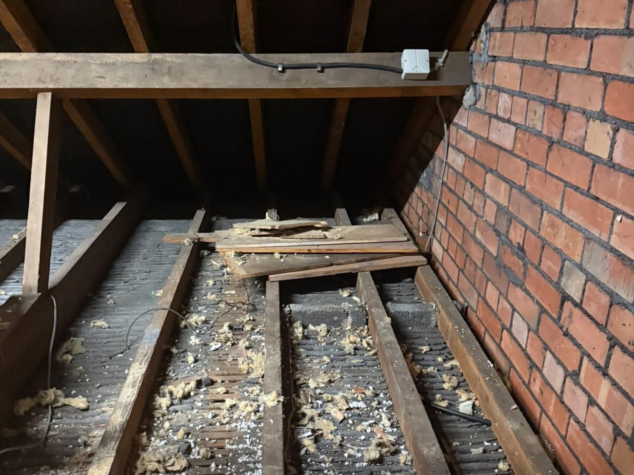 Stoke Gifford loft stripped back to the joists, with debris and remnants of the old contaminated insulation