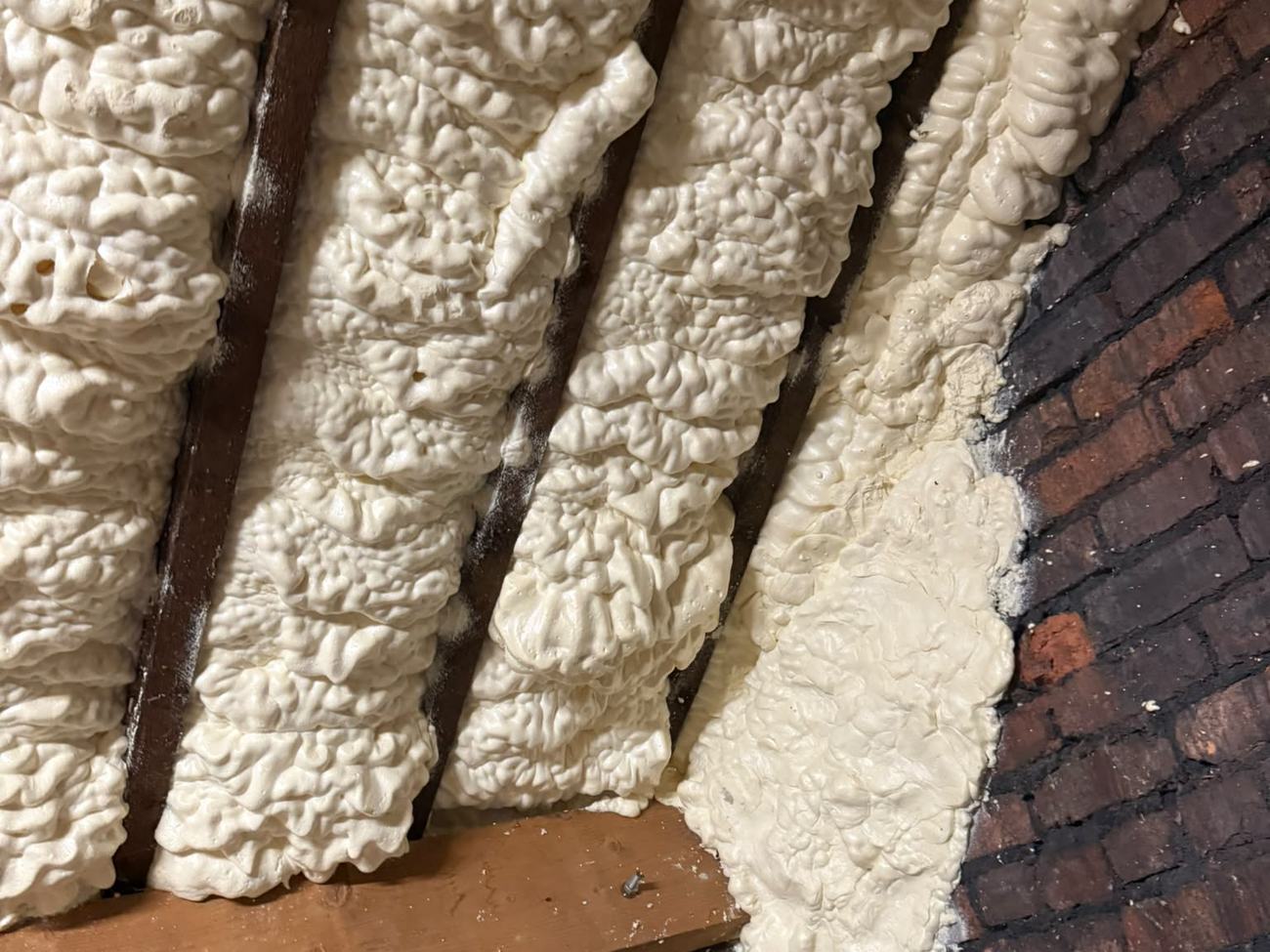 Spray foam applied between the rafters and across the gable wall of a Basingstoke loft